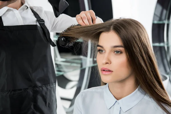 Hairdresser brushing hair of woman — Stock Photo, Image