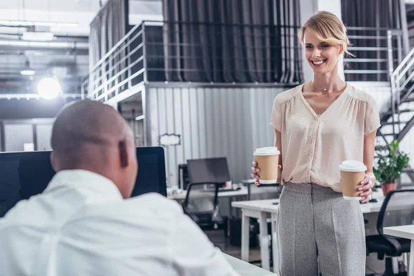 Businesswoman bringing coffee to colleague — Stock Photo, Image