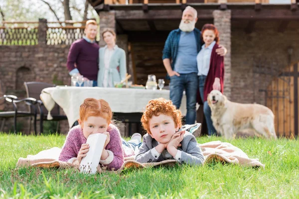 Niños descansando sobre hierba verde — Foto de Stock