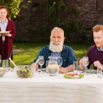 Homens felizes sentados à mesa