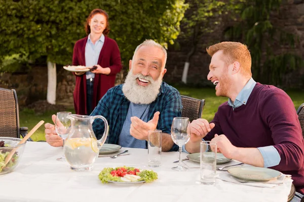 Homens felizes sentados à mesa — Fotografia de Stock