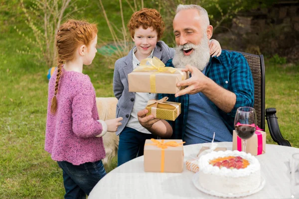 Kids greeting grandfather at birthday celebration — Stock Photo, Image