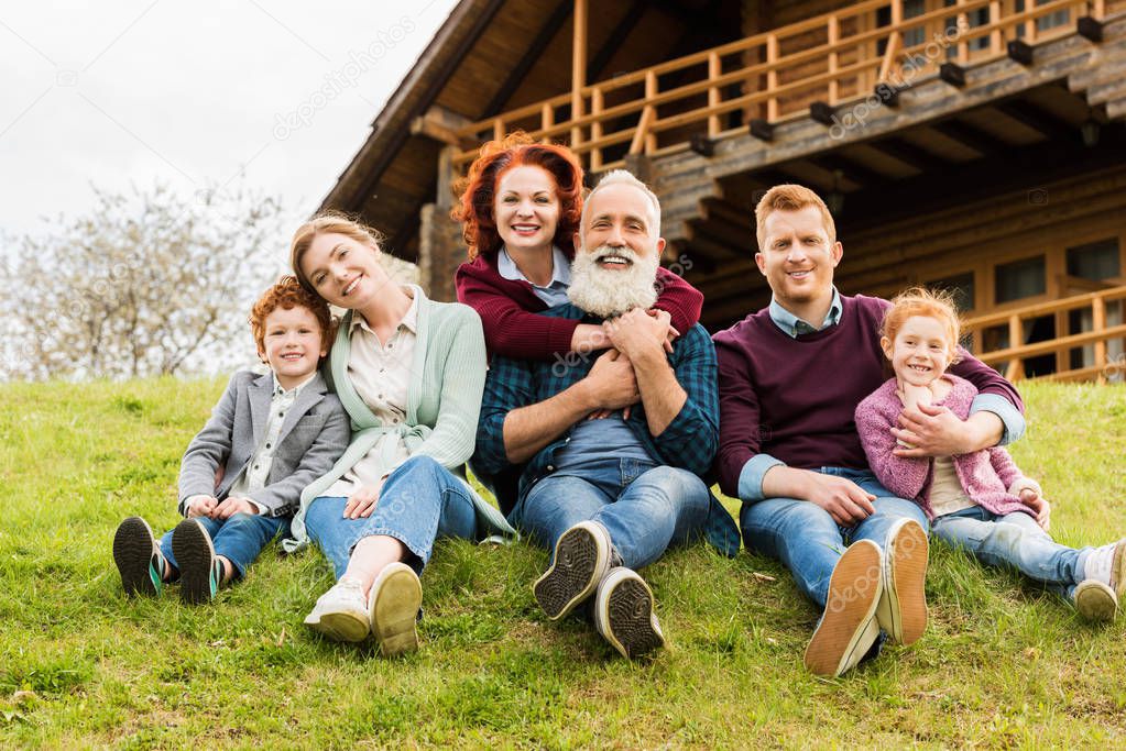 Happy family resting together in village near country house