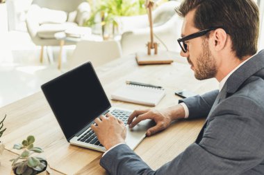 Dizüstü bilgisayar kullanan iş adamı