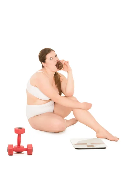 Overweight woman with donut, dumbbells and scales — Stock Photo, Image