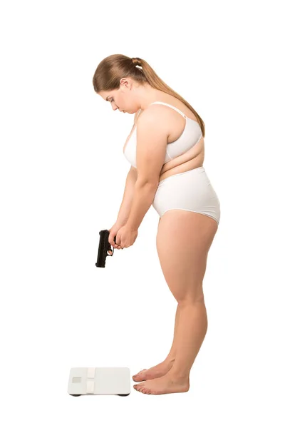 Frau mit Waffe steht an Waage — Stockfoto