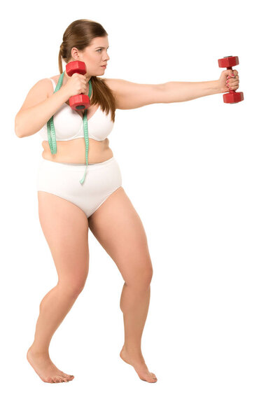 Толстая женщина тренируется с гантелями
