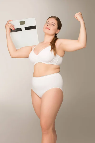 Толстая женщина позирует с весами — стоковое фото
