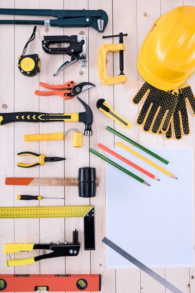 Top view of different tools with blueprint on wooden tabletop — Stock Photo