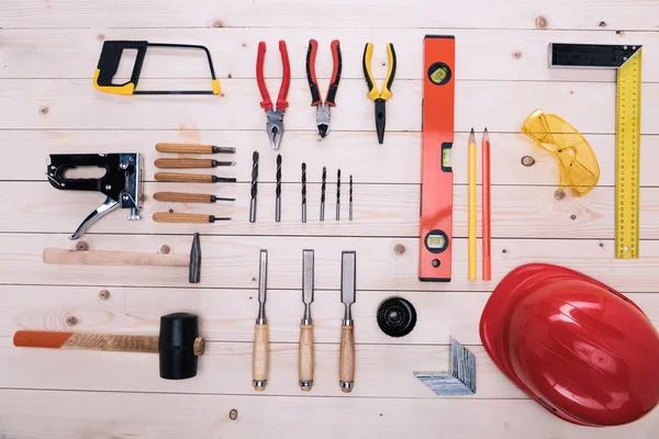 Top view of set of construction tools and hard hat on wooden table — Stock Photo