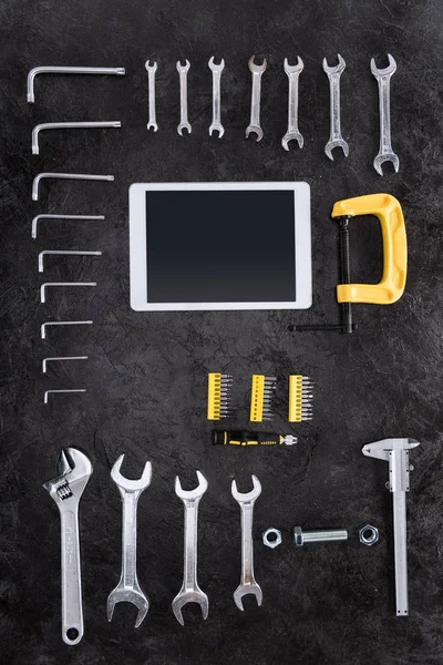 Vue de dessus de divers outils de construction et tablette numérique sur noir — Photo de stock