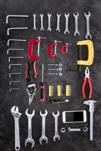 Vista superior do conjunto de ferramentas de construção e smartphone em preto — Fotografia de Stock