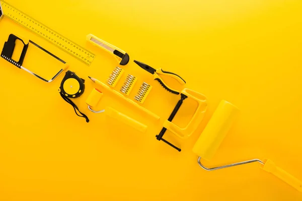 Top view of various work tools and ruler on yellow — Stock Photo