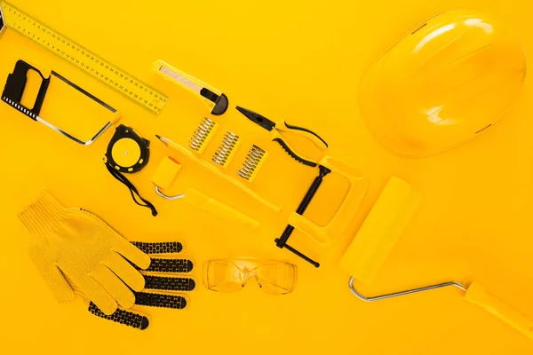 Vista superior de varias herramientas y equipos de trabajo en amarillo - foto de stock