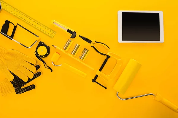 Top view of various work tools, equipment and digital tablet on yellow — Stock Photo