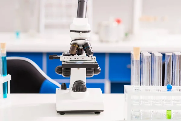 Tubes and microscope in laboratory — Stock Photo