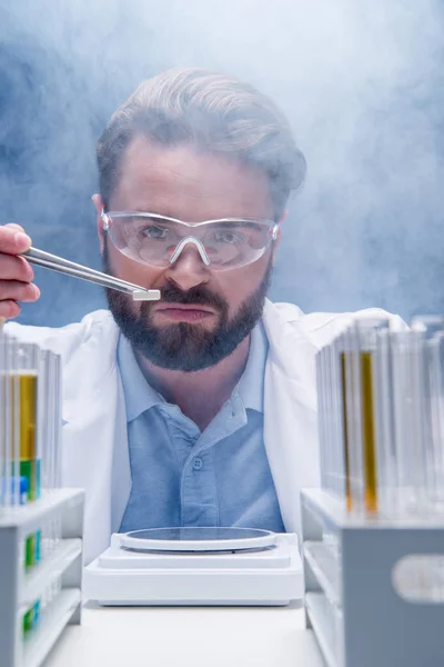 Chemist in goggles with reagents — Stock Photo