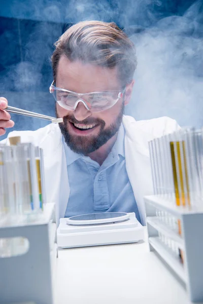 Chemist in goggles with reagents — Stock Photo