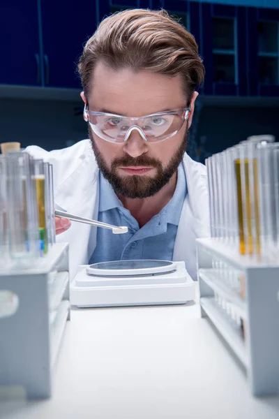 Chemist in goggles with reagents — Stock Photo