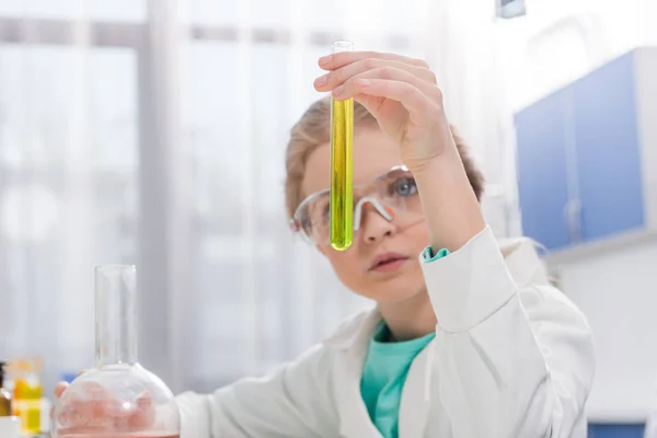 Mädchen in Schutzbrille mit Fläschchen — Stockfoto