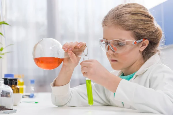 Mädchen in Schutzbrille mit Fläschchen — Stockfoto