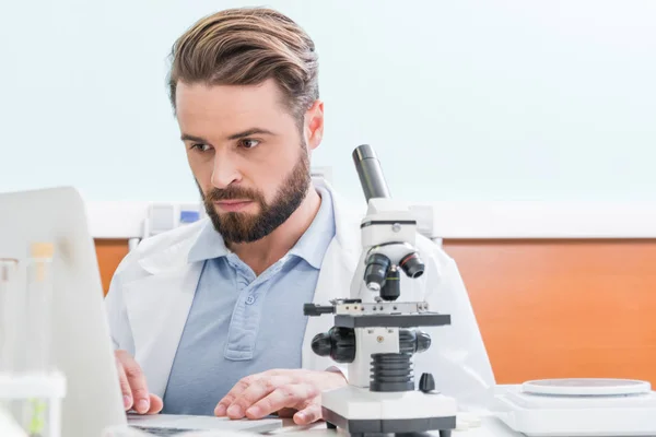 Científico trabajando con microscopio - foto de stock