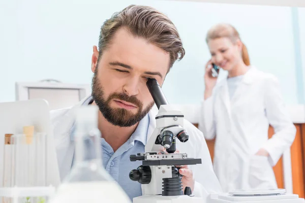 Científico trabajando con microscopio - foto de stock