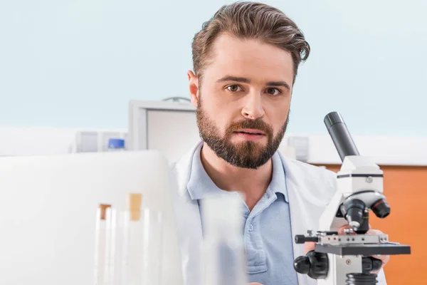 Científico trabajando con microscopio - foto de stock