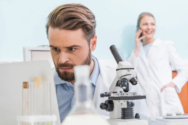 Científico trabajando con microscopio - foto de stock