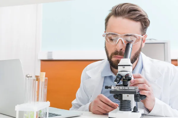 Científico trabajando con microscopio - foto de stock