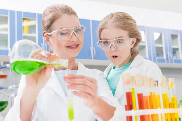 Scienziato e ragazza con tubi — Foto stock