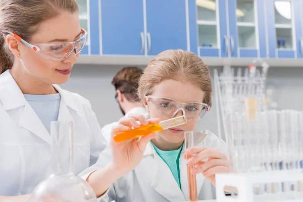 Scienziato e ragazza con tubi — Foto stock