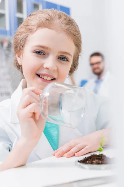 Дівчина з зеленою рослиною в лабораторії — Stock Photo