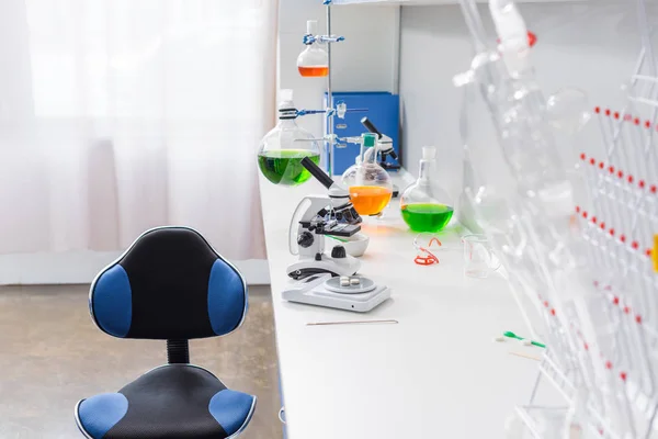 Microscope and reagents in laboratory — Stock Photo
