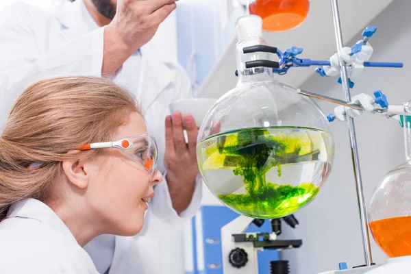Profesor y estudiante haciendo experimento - foto de stock