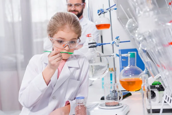 Profesor y estudiante haciendo experimento - foto de stock