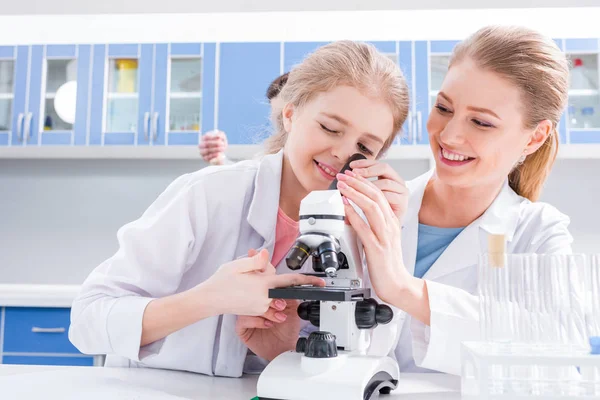 Enseignant et étudiant travaillant au microscope — Photo de stock