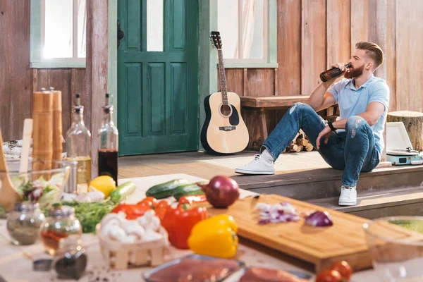 Man drinking beer on porch — Stock Photo