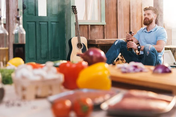 Man drinking beer on porch — Stock Photo