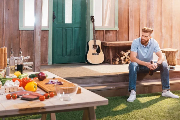 Man drinking beer on porch — Stock Photo