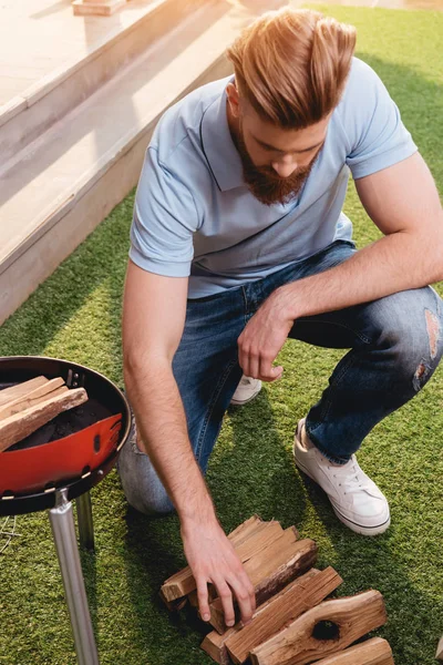 Young man looking at firewood — Stock Photo