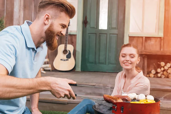 Couple grilling meat and vegetables — Stock Photo