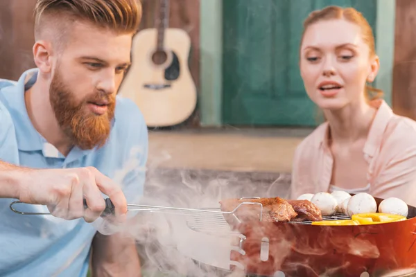 Couple griller de la viande et des légumes — Photo de stock