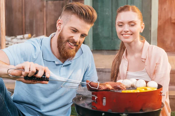 Couple griller de la viande et des légumes — Photo de stock