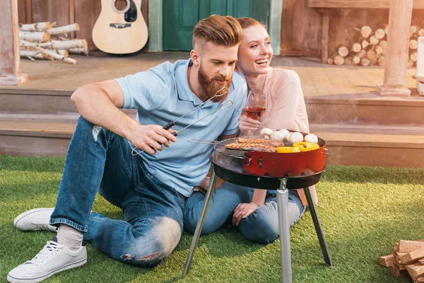 Couple grilling meat and vegetables — Stock Photo