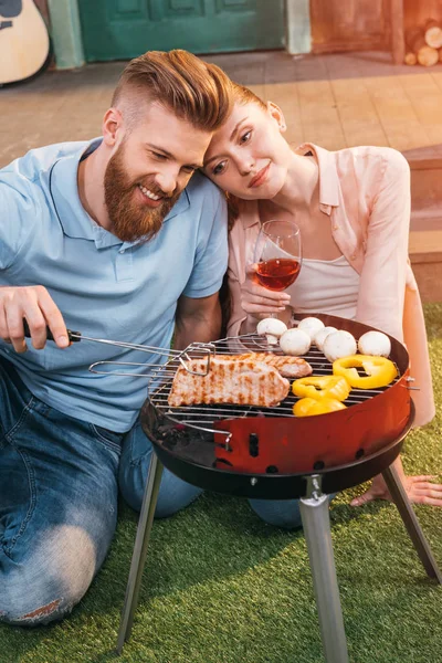 Couple grilling meat and vegetables — Stock Photo