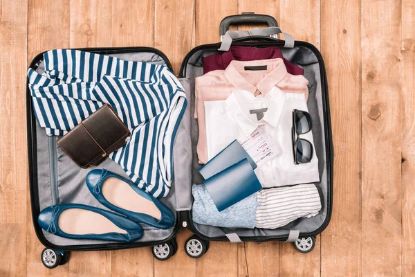 Аксессуары путешественника в открытом багаже — стоковое фото