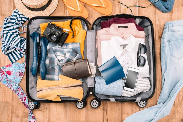 Аксесуари мандрівника у відкритому багажі — стокове фото
