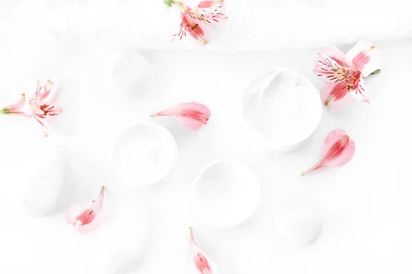 Fleurs et crème en récipients — Photo de stock