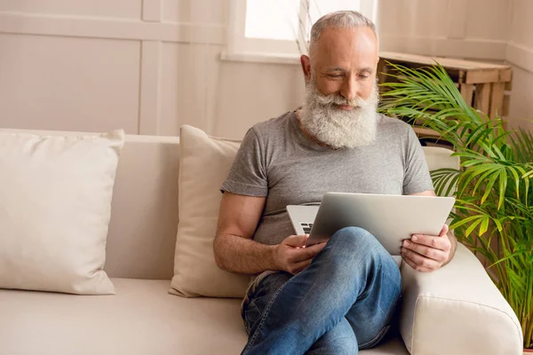 Uomo anziano utilizzando il computer portatile — Foto stock